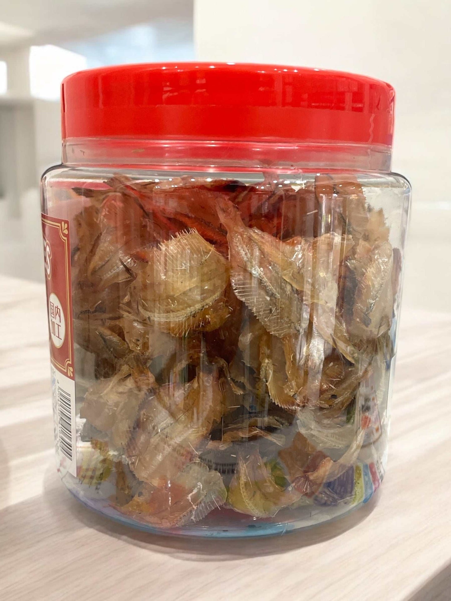 Packaged roasted sardines in clear jar with red lid, labeled 一榮食品, 300g.