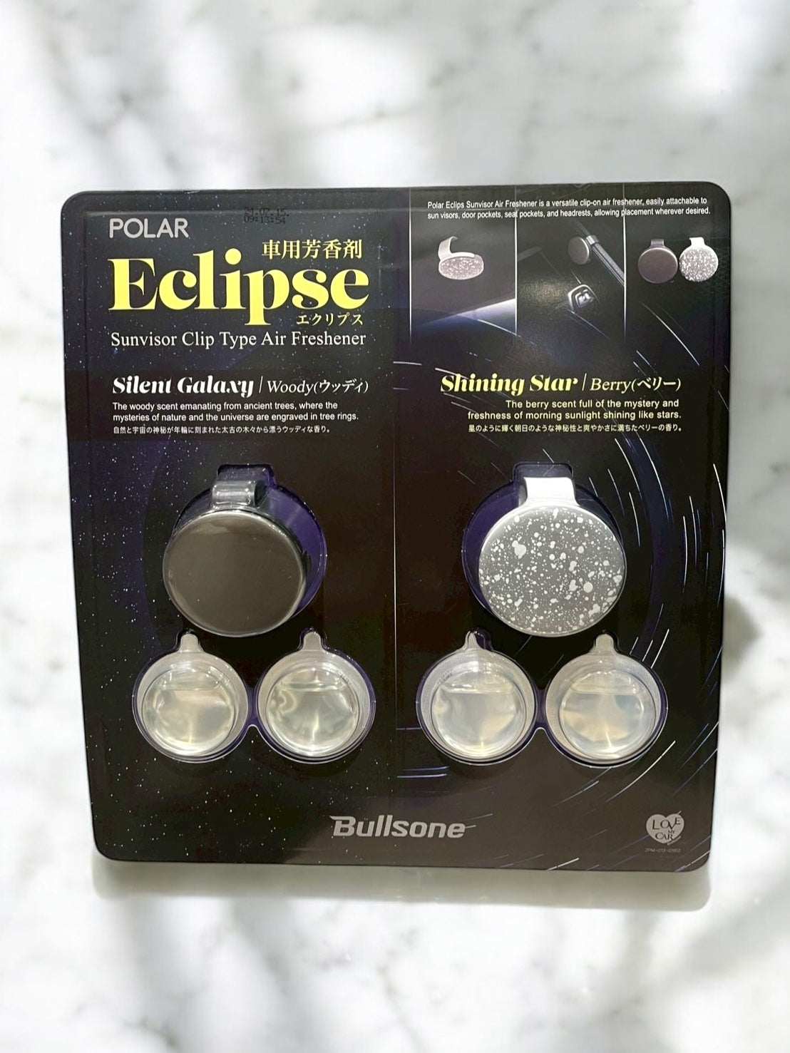 Car air freshener with sunvisor clip, features woody and berry scents, includes two clips and four cartridges for long-lasting fragrance.