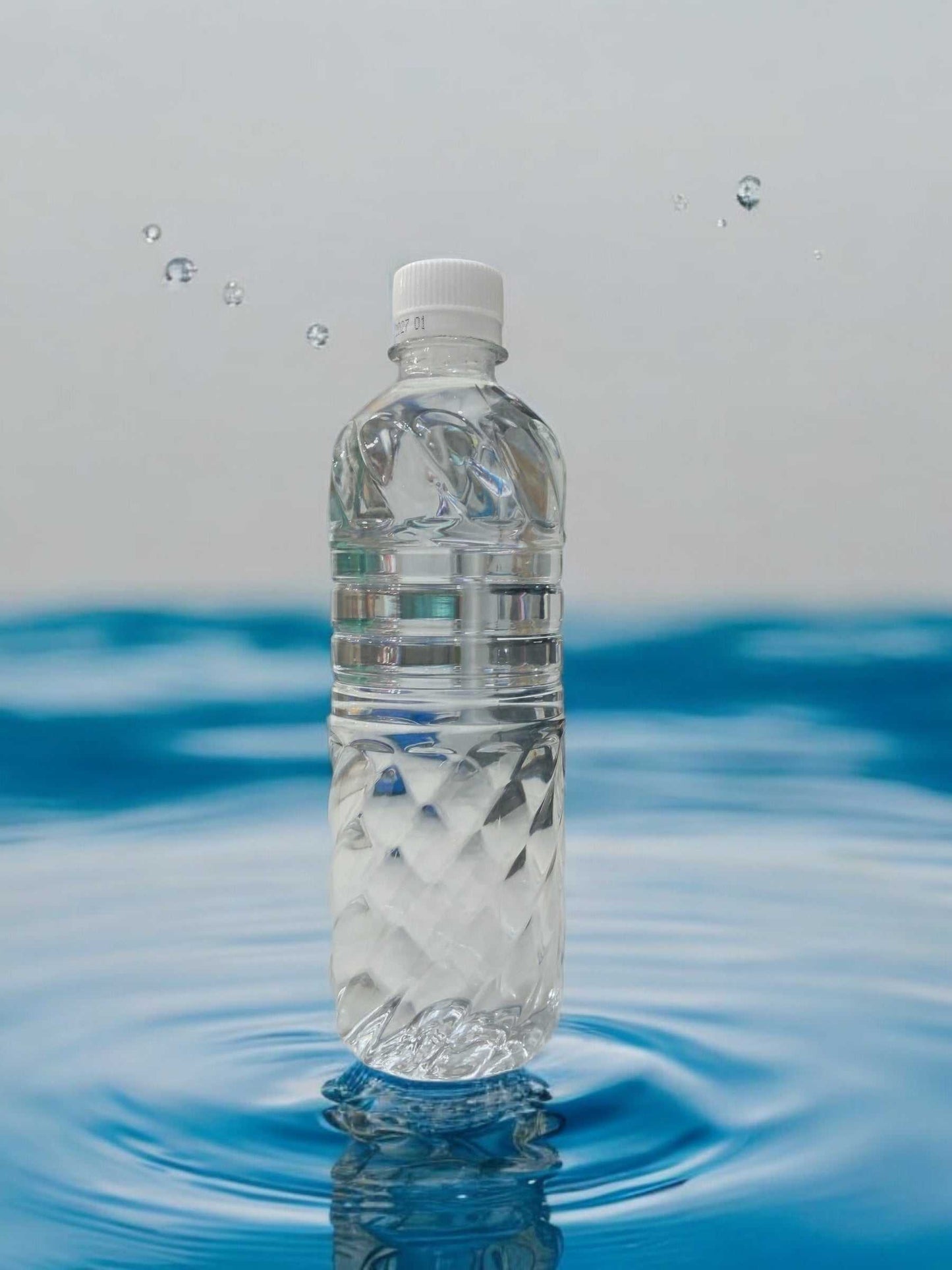 KS天然ミネラルウォーター500mlのラベルレスペットボトルが水の上に立っています。