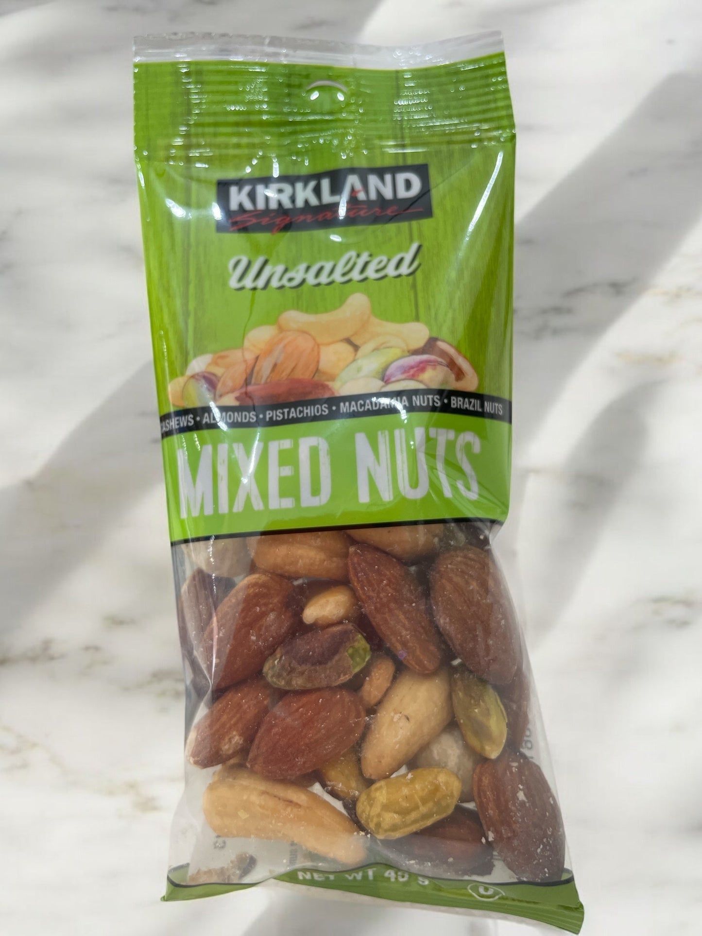 Kirkland Signature unsalted mixed nuts 45g pack, featuring cashews, almonds, pistachios, Brazil nuts, and macadamia nuts in individual packaging.