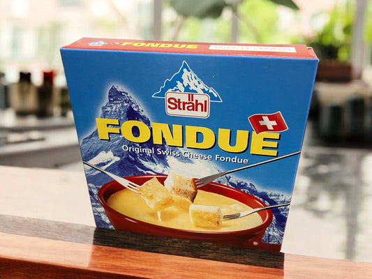 Swiss cheese fondue by Strahl in blue packaging with mountain design.